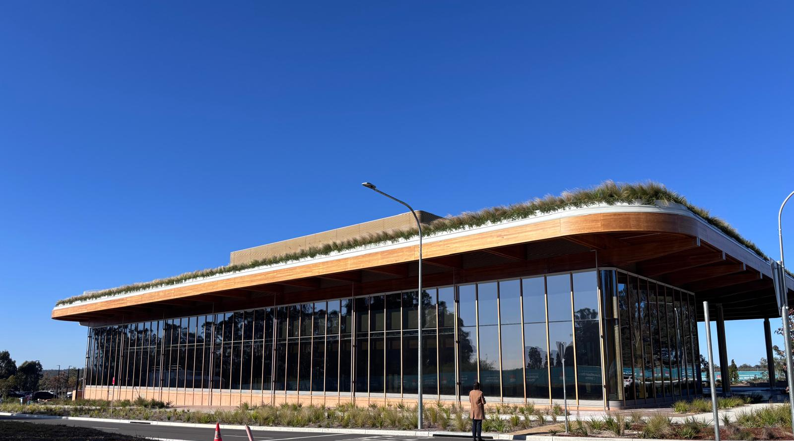 The First Building at Bradfield City, a curved engineered timber roof over a fully glazed façade, with bamboo battens and flooring